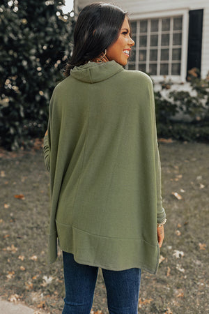 Army green tunic with cowl neckline and long sleeves, styled with jeans.