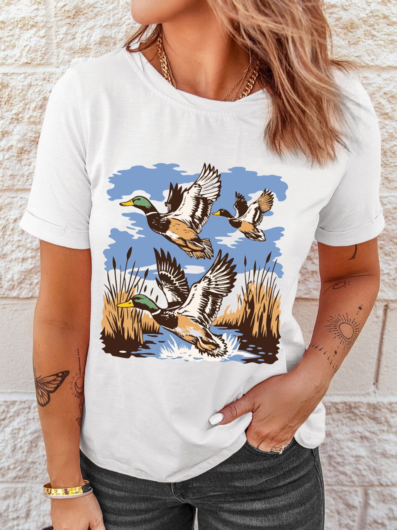 White cotton tee with a graphic of three ducks flying over reeds and water.