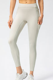Cream athletic leggings with utility pockets and contrast stitching.