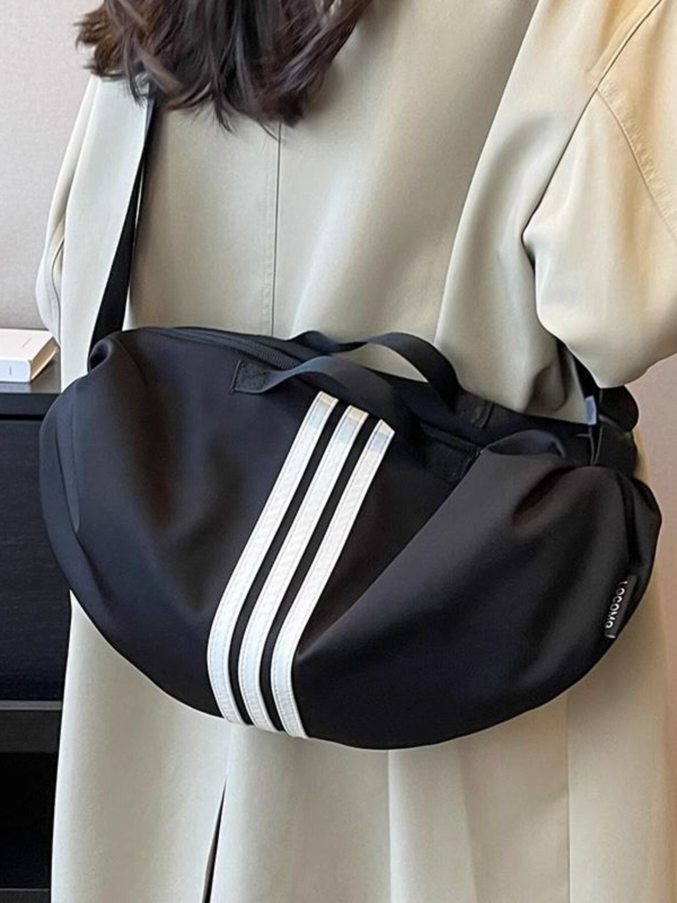 Black Oxford cloth crossbody bag with white stripes and adjustable strap.