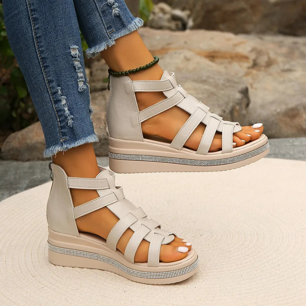 Ivory gladiator wedge sandals with crystal trim detail and crisscross straps.