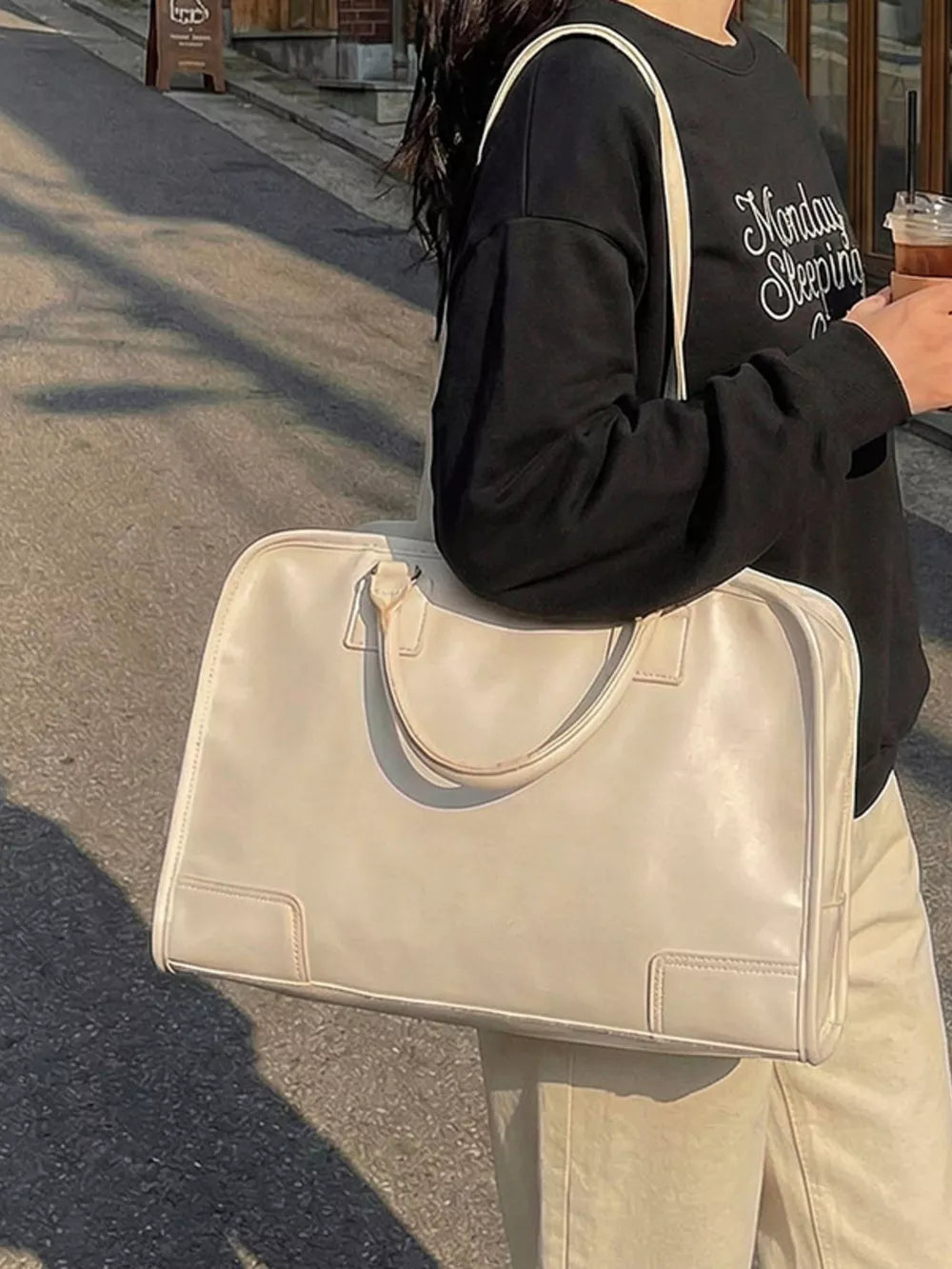 Cream pu leather travel bag with top handles and versatile strap.