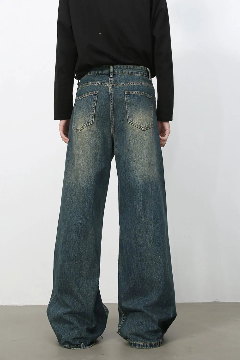 Dark wash wide-leg denim jeans with distressed details and a relaxed fit.