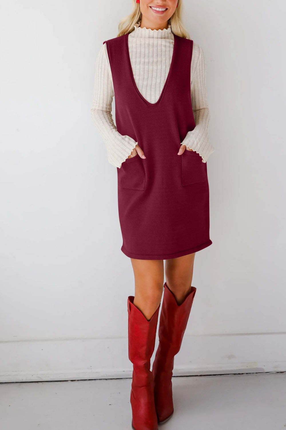 Burgundy sweater dress with deep V-neck, sleeveless, and two front pockets.