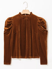 Brown velvet mock neck blouse with ruffled neckline and puffed sleeves.