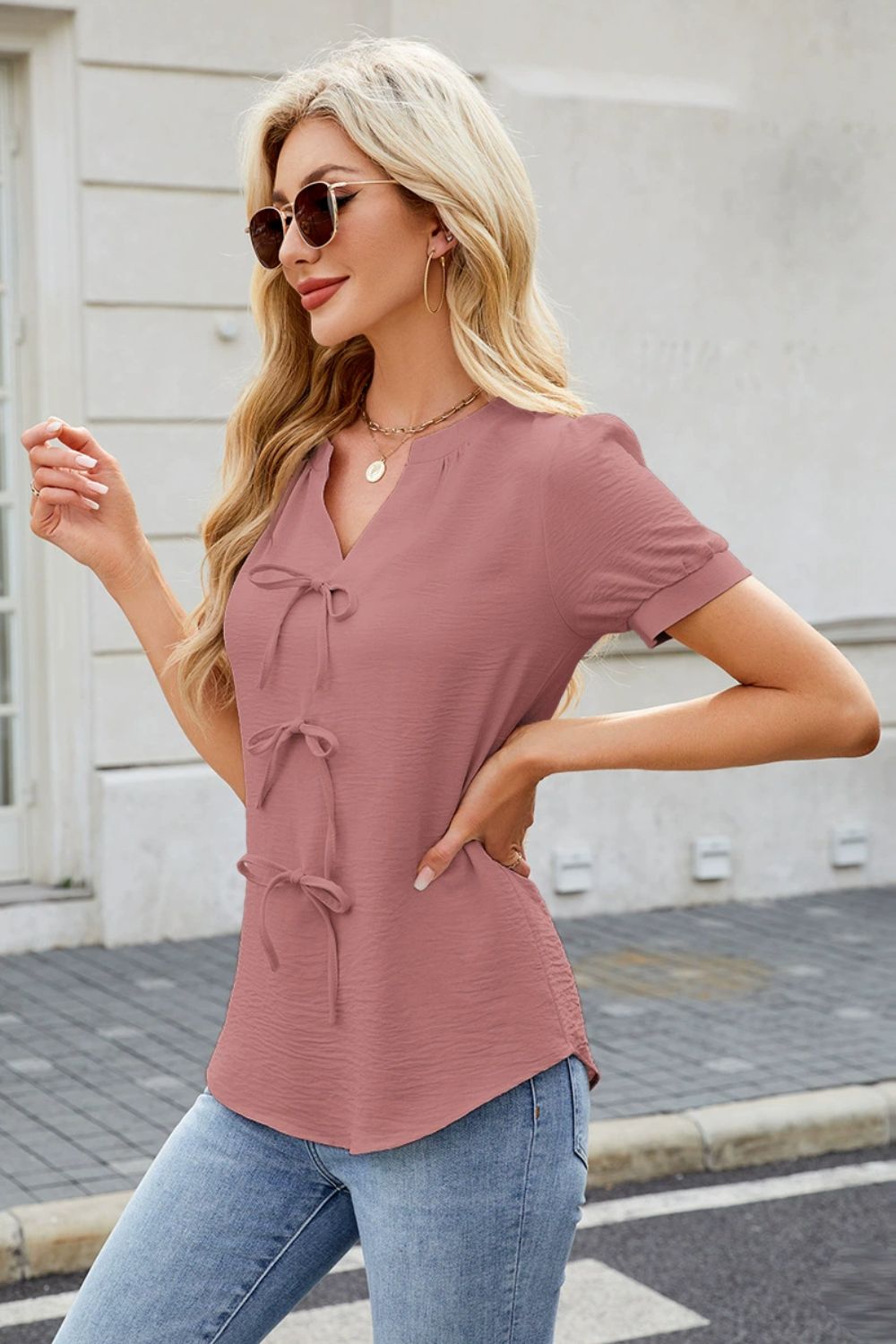 Dusty pink textured blouse with bow-tie front detail and short sleeves