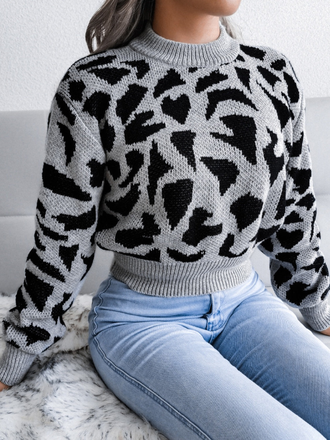 Gray abstract knit cropped sweater with mock neck and long sleeves.