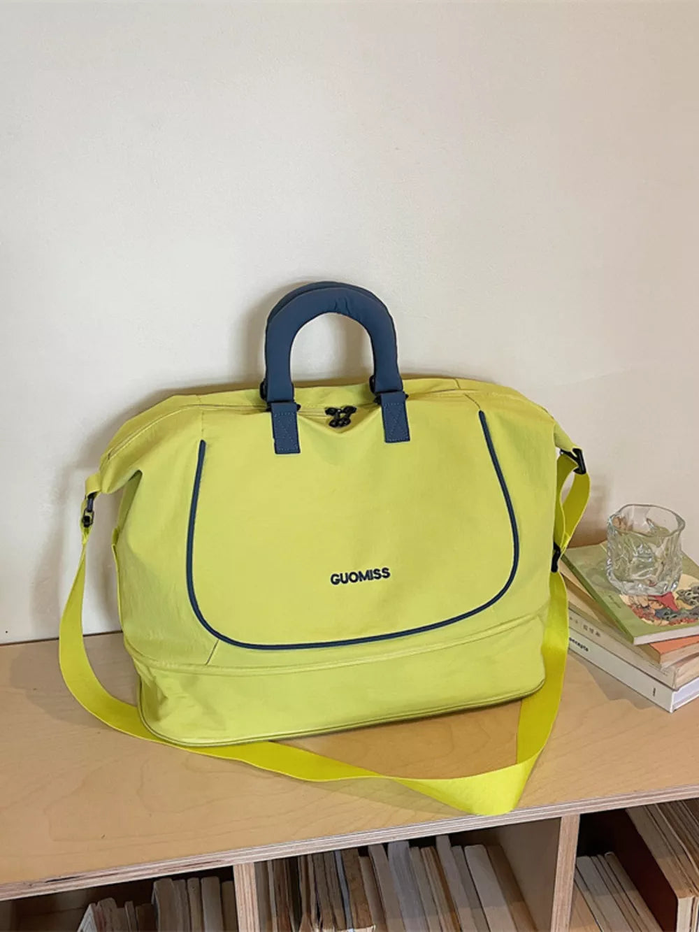 Chartreuse Oxford cloth duffle bag with navy trim and handles, "GUOMISS" logo.
