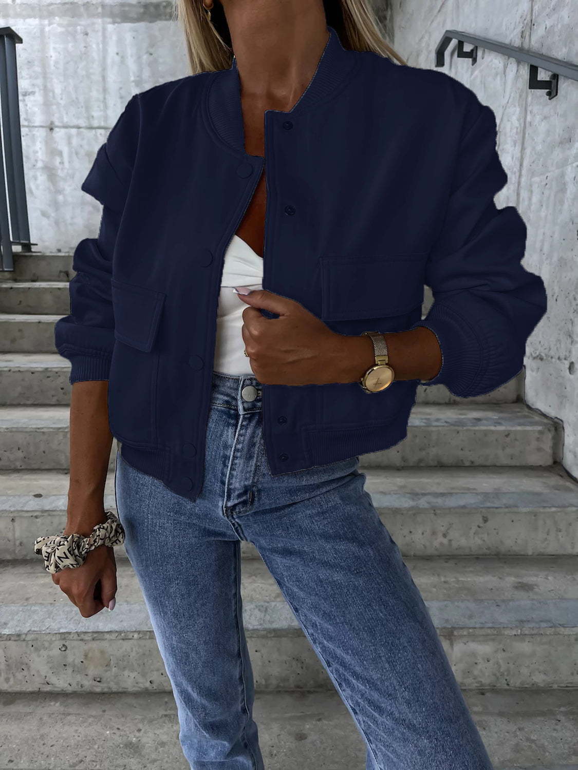 Navy faux leather bomber jacket with button front, chest pockets, and ribbed cuffs.