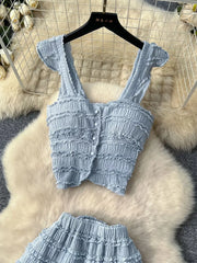 Light blue textured two-piece set with ruffled details, square neck, button front crop top and tiered skirt.