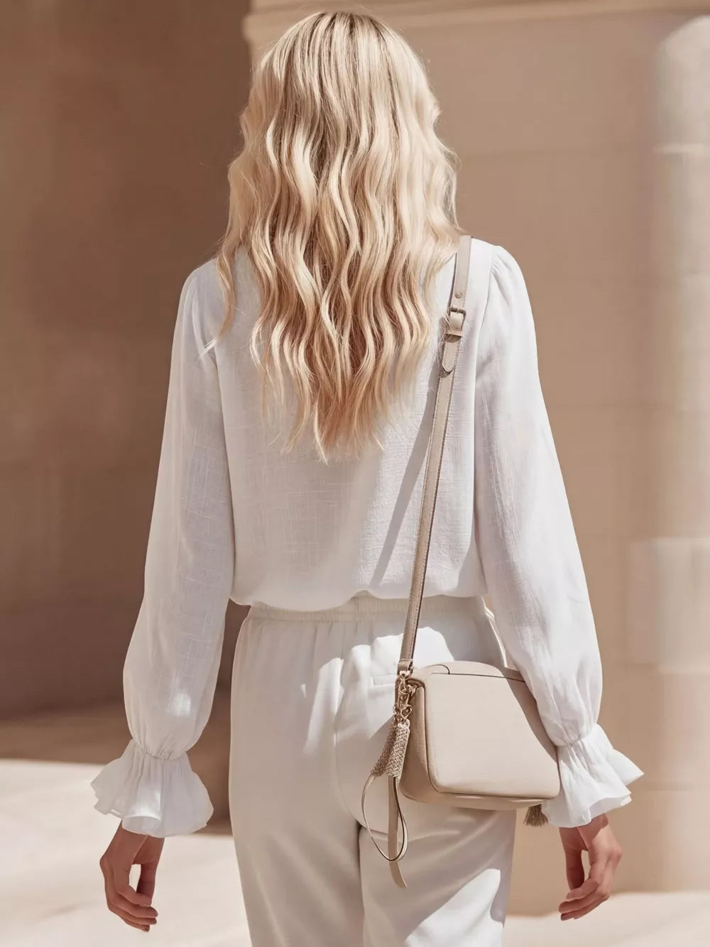 White maternity shirt with ruffled cuffs and V-neck detail.