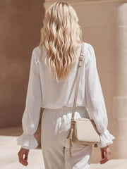 White maternity shirt with ruffled cuffs and V-neck detail.