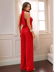 Red halter jumpsuit with wide legs and a tie detail at the neck.