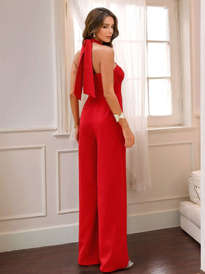 Red halter jumpsuit with wide legs and a tie detail at the neck.