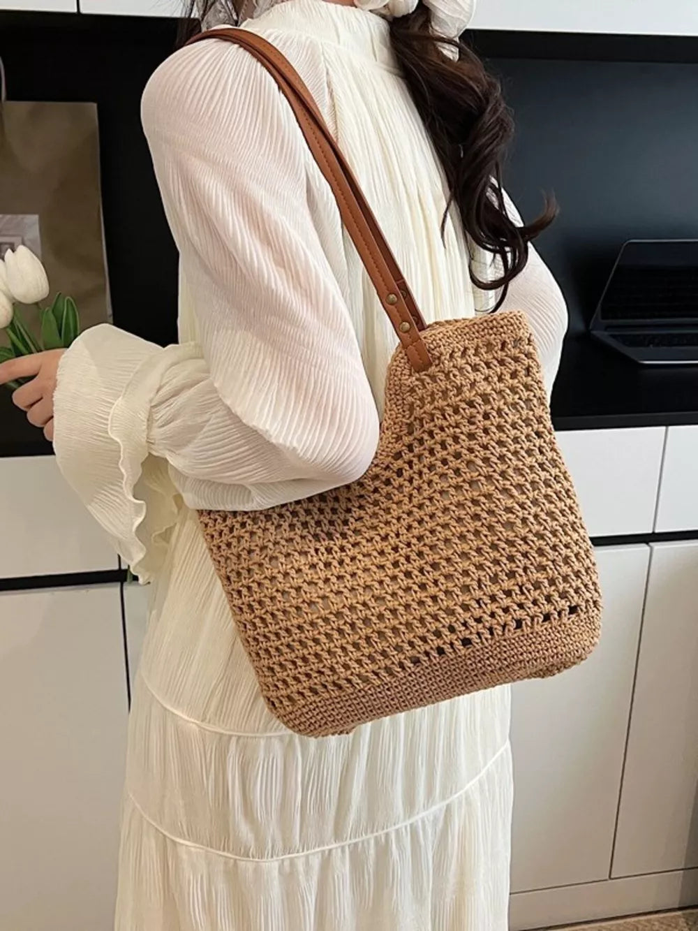 Beige woven straw shoulder bag with leather strap, open weave detail