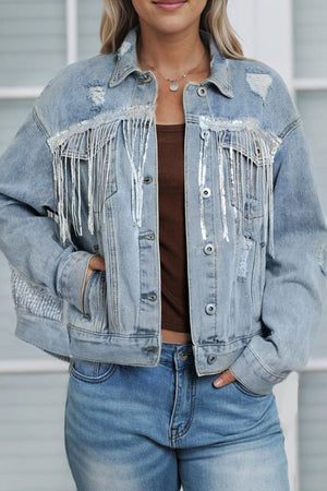 Denim trucker jacket in medium wash with sequin fringe and distressed details.