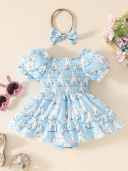 Sky blue baby dress with smocked bodice, puff sleeves, bunny print, and matching headband.