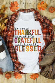 White cotton crewneck t-shirt with colorful typography reading "so very THANKFUL incredibly GRATEFUL unbelievably BLESSED