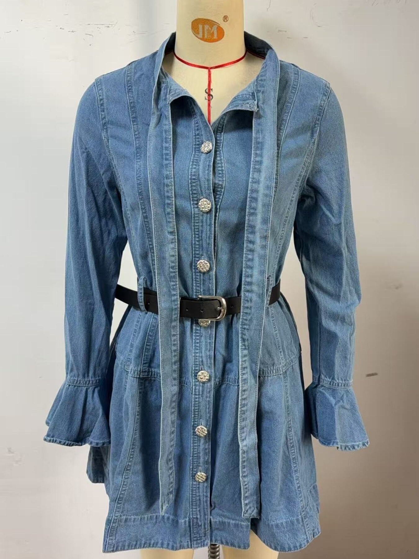 Blue denim dress with button front, tie neck, flounce sleeves, and black belt.