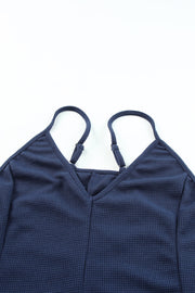 Navy relaxed-fit jersey jumpsuit with adjustable spaghetti straps and V-neck.