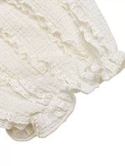 White textured maternity t-shirt with ruched detailing and ruffled puff sleeves.