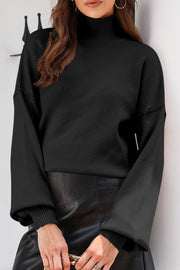 Black knit sweater with mock neck and balloon sleeves, ribbed cuffs.