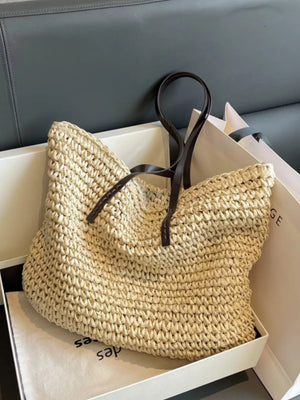 Natural woven straw shoulder bag in khaki with dark brown leather straps.