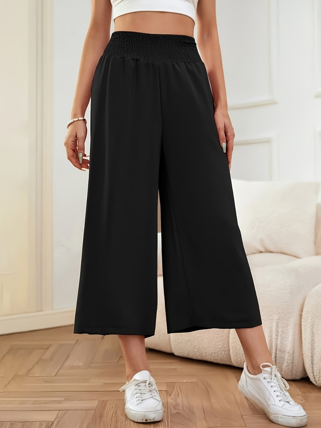 Black smocked waist culotte trousers with a wide leg and cropped length.