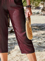 Burgundy cropped denim trousers with elastic waist, capri length, casual style.