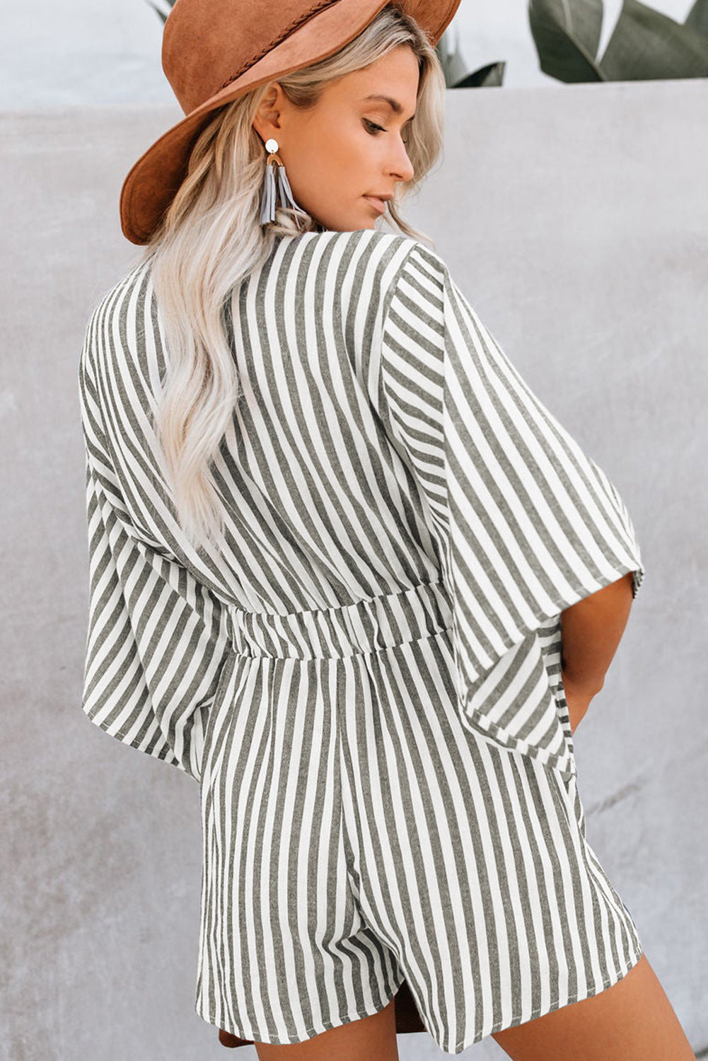 Striped tie-front kimono jumpsuit in dark gray with wide sleeves and a cinched waist.