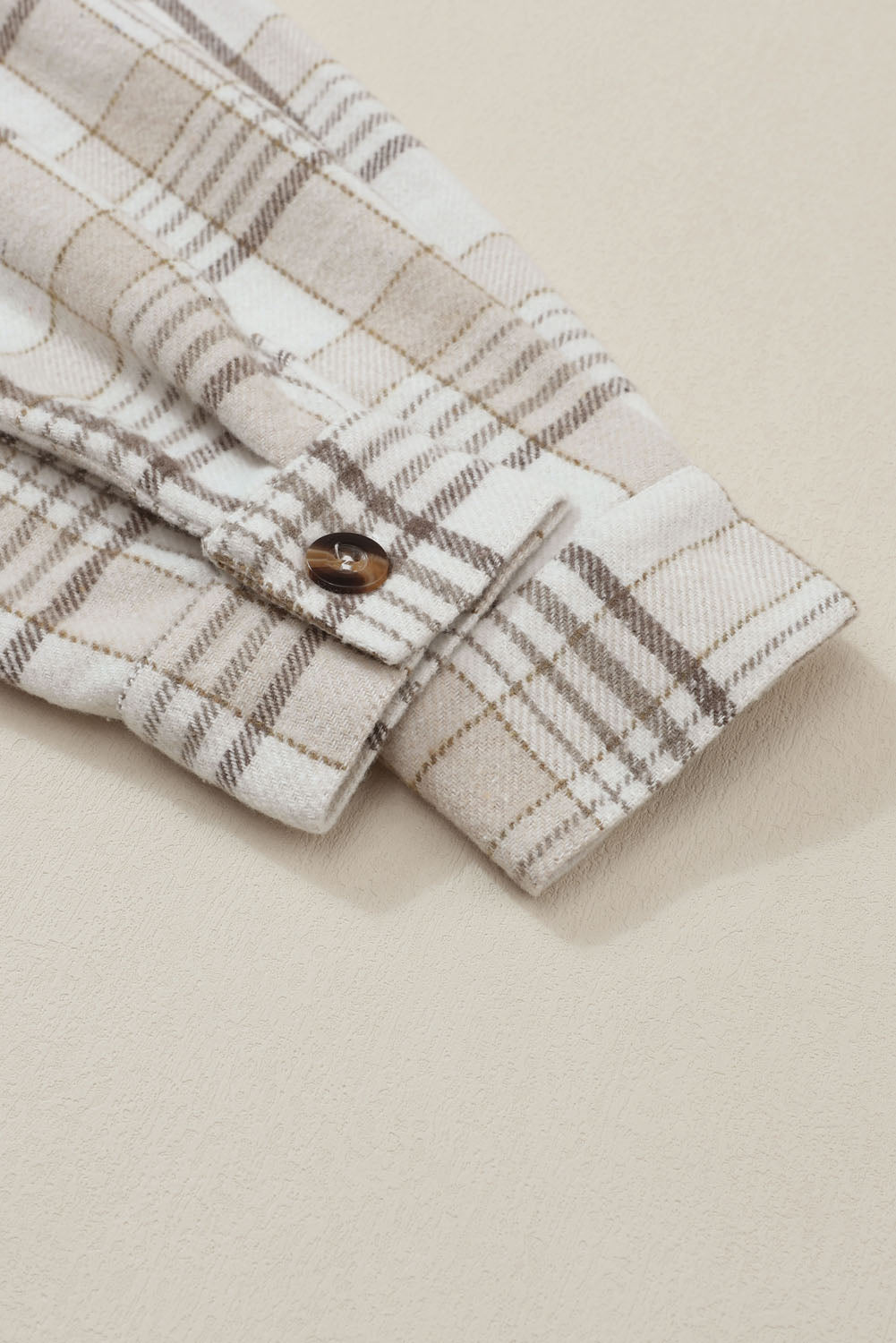Oversized plaid shacket with attached hoodie, featuring a button cuff detail on the sleeve.