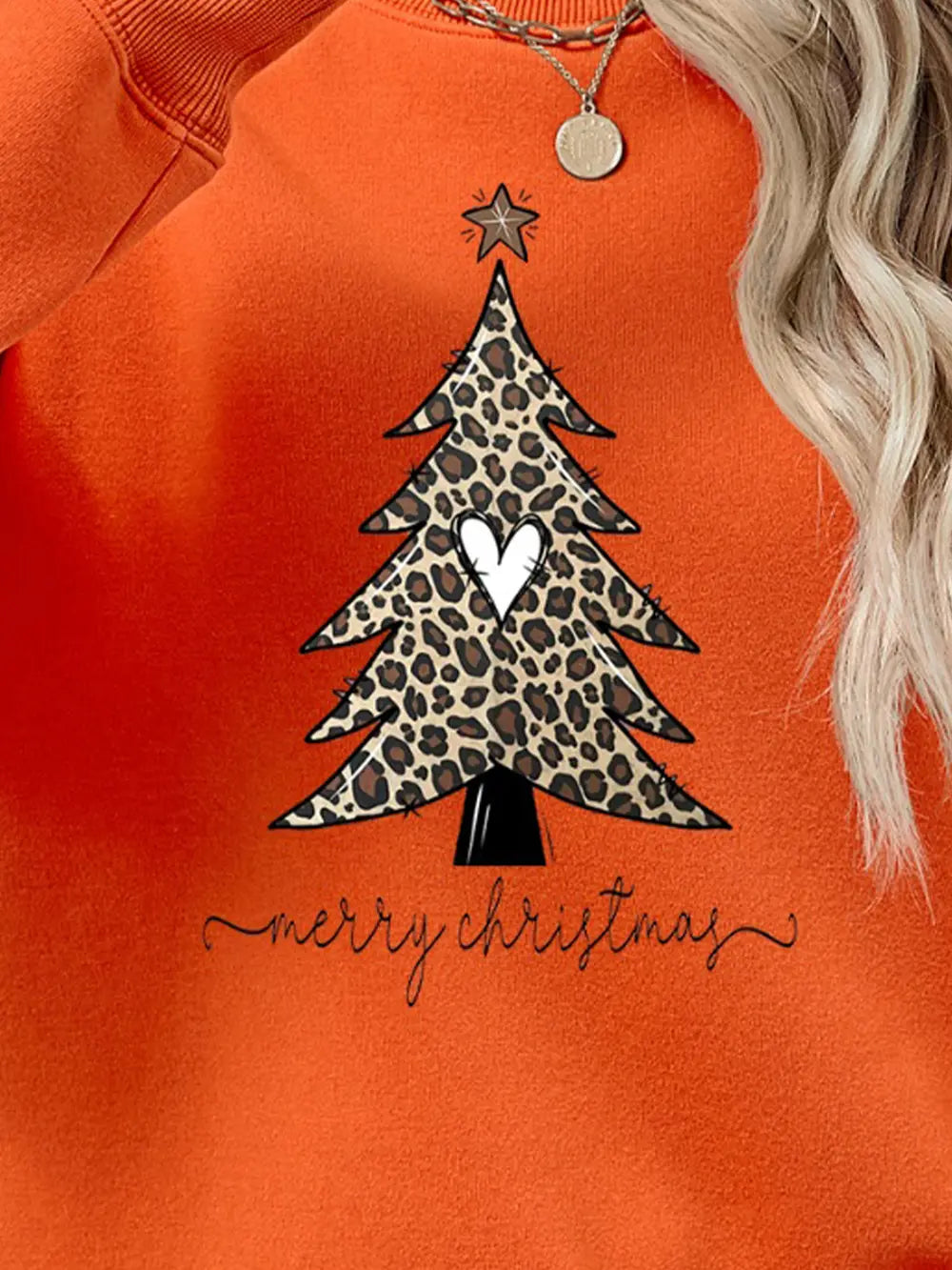 Orange sweatshirt with leopard print Christmas tree graphic and merry christmas text