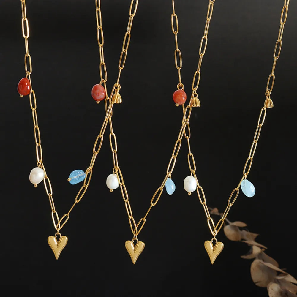 Gold paperclip chain necklace with heart charm and mixed beads.