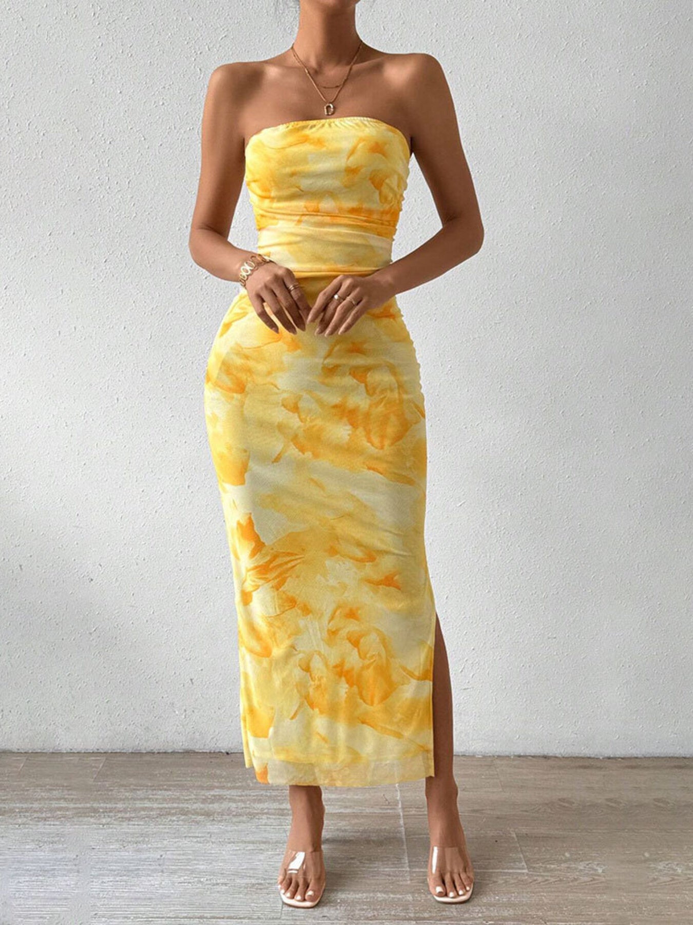 Yellow tie-dye ruched strapless bodycon midi dress with a thigh slit.