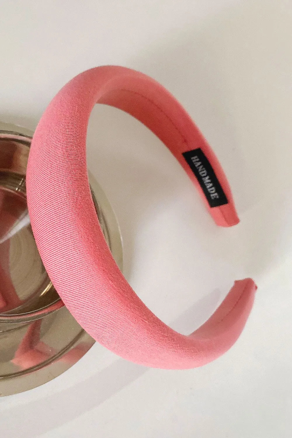 Padded headband in strawberry textured fabric with a black "Handmade" tag.