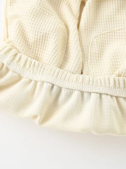 Beige waffle knit toddler tee and shorts set detail with ruffled hem and elastic waistband.