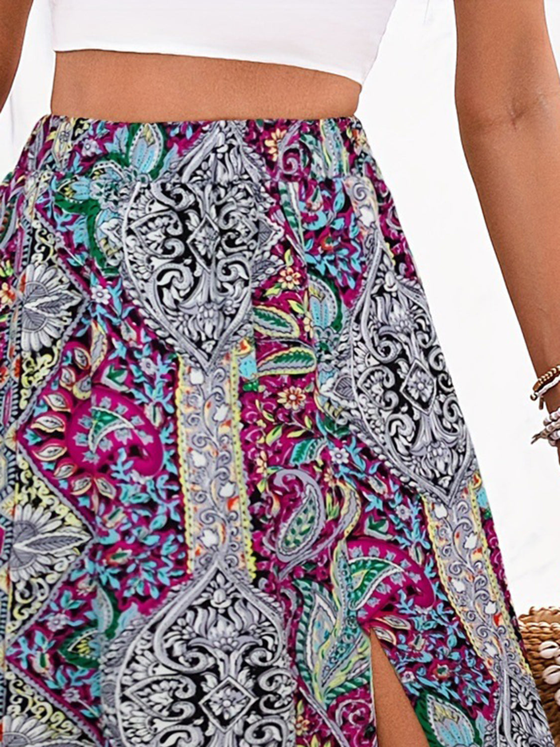 Maxi skirt with paisley print in magenta, yellow-green, and black, featuring a thigh slit.