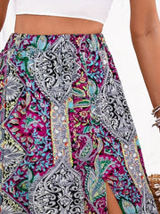 Maxi skirt with paisley print in magenta, yellow-green, and black, featuring a thigh slit.