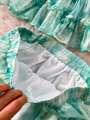 Light green floral ruffle bikini bottoms with white lining and elastic waistband.