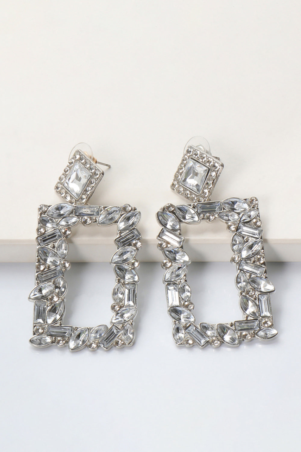 Geometric jewel box earrings with clear crystals and silver alloy.