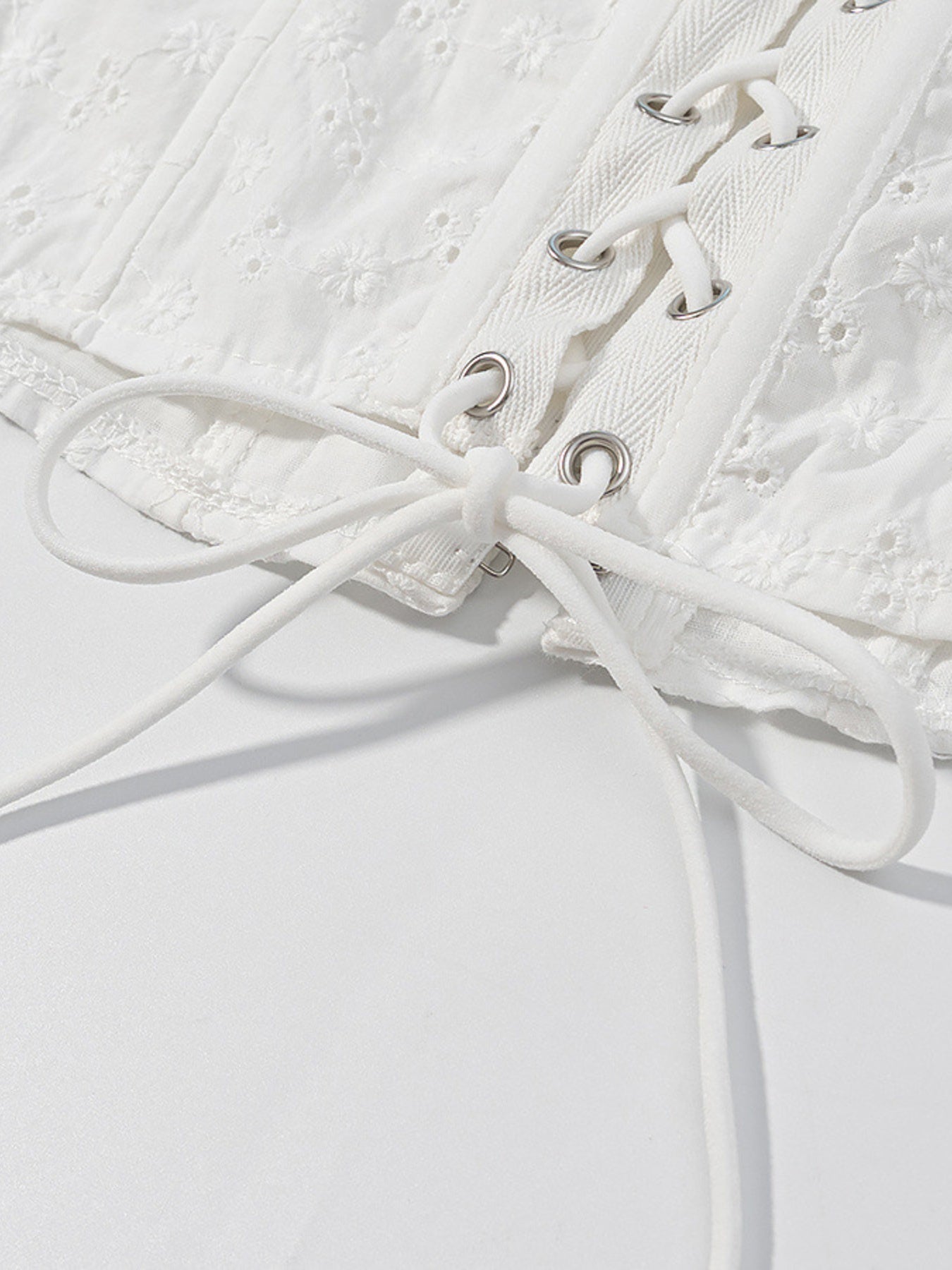 White eyelet tank top with corset lace-up detail and ruffle trim