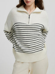 Cream ribbed knit sweater with black stripes and a half-zip neckline.