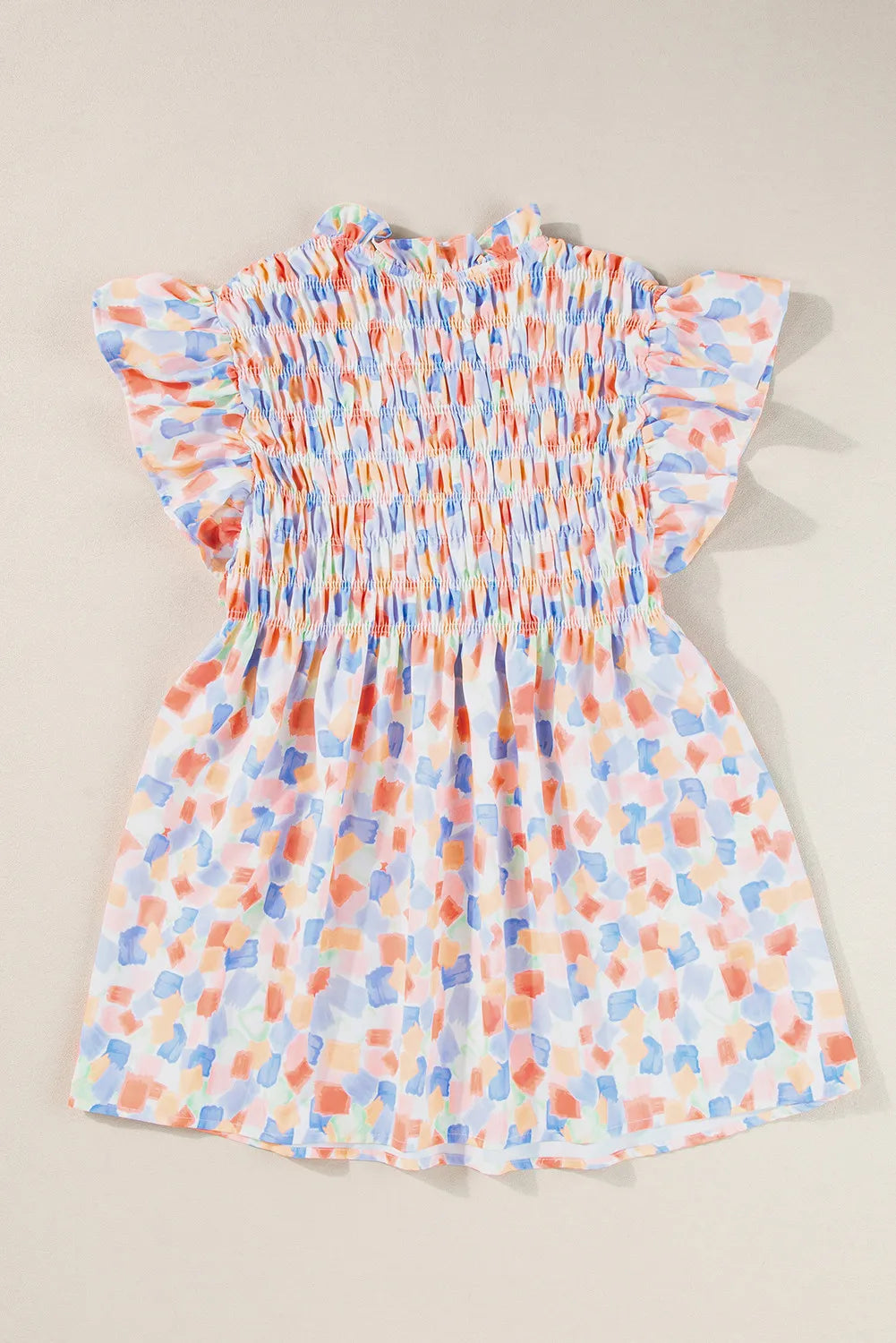 Smocked bodice blouse with brushstroke print and flutter sleeves in pastel colors.