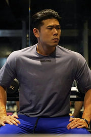 Oversized dark gray t-shirt with a small black logo on the chest, crew neck, short sleeves.