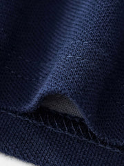 Navy blue cotton polo shirt fabric detail with visible stitching.