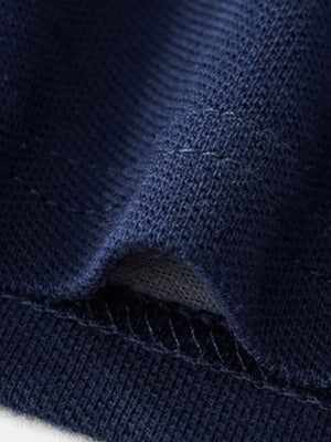 Navy blue cotton polo shirt fabric detail with visible stitching.