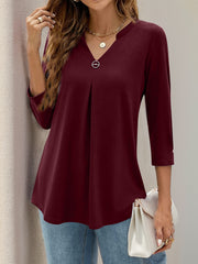 Burgundy V-neck three-quarter sleeve top with front pleats and a decorative button detail.