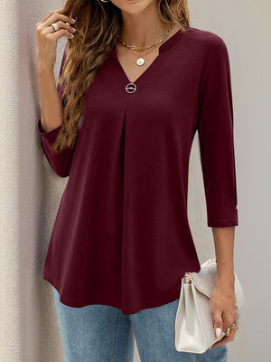 Burgundy V-neck three-quarter sleeve top with front pleats and a decorative button detail.