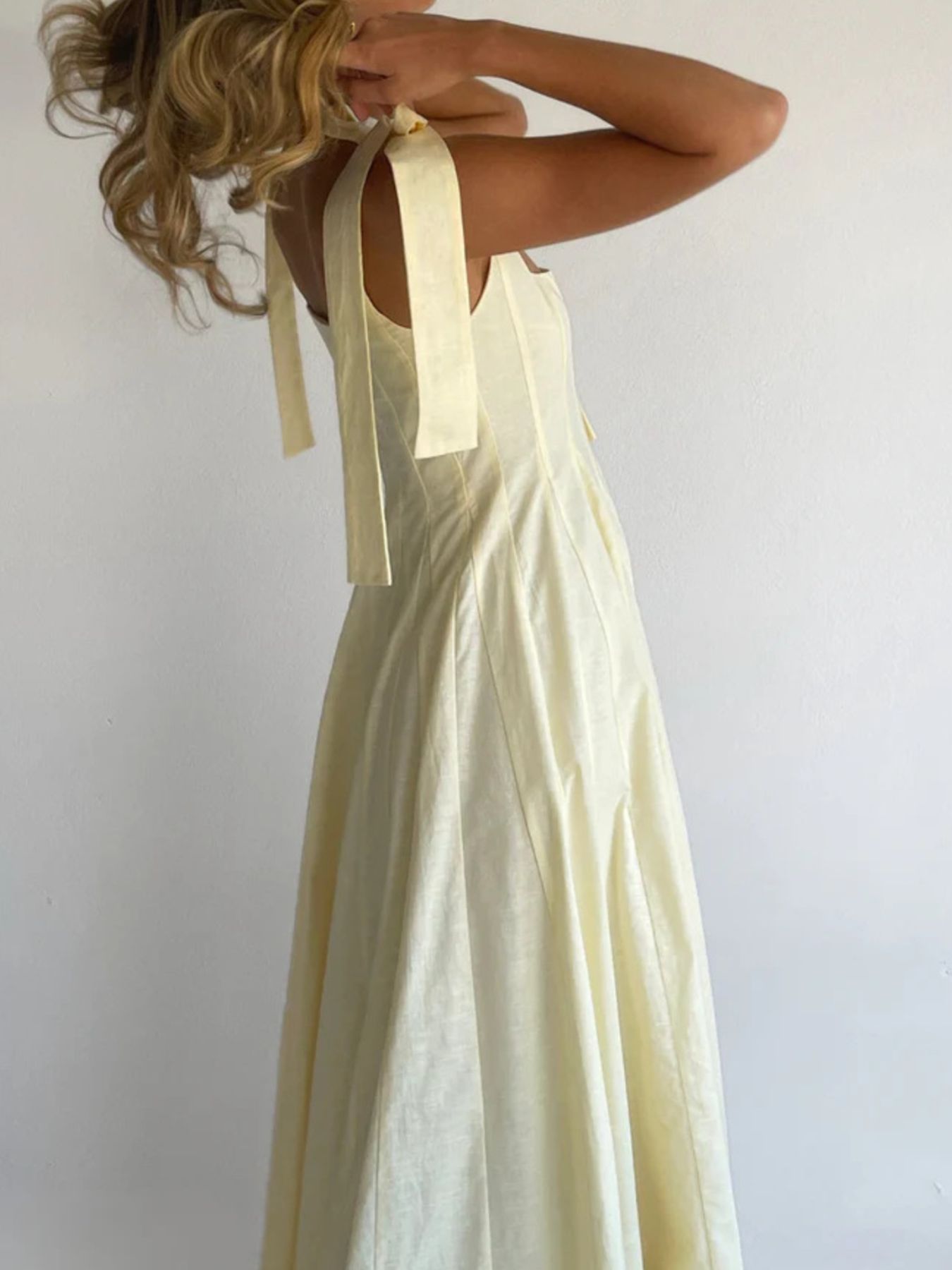Yellow maxi dress with bow-tie shoulder straps and a flowing skirt.