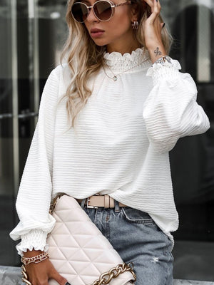 White textured puff sleeve blouse with smocked neck and cuffs.